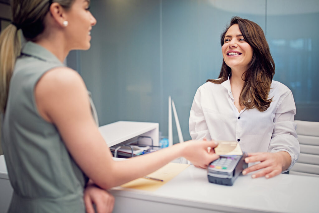 Woman is paying on a reception desk in a beauty treatment clinic